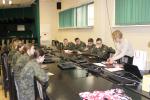 W sali siedzą uczniowie w mundurach wojskowych i słuchają prelekcji o podatkach