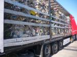 Na zdjęciu widać bok ciężarówki ze sprasowanymi belami odpadów