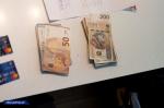 Na stole leżą banknoty o nominałach 100 i 200 zł