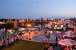 Widok Bulwaru Wschodniego w Gorzowie Wielkopolskim - jego wizualizacja po przebudowie - promenada, oczka wodne, rzeka Warta, cumujące statki, spacerujący ludzie na promenadzie wieczorową porą