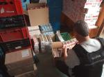 funkcjonariusz służby celno-skarbowej w magazynie liczy paczki papierosów