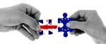 Dwie dłonie zwrócone do siebie trzymające puzle symbolizujace flage Unii Europejskiej i Wielkiej Brytanii.