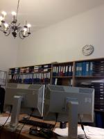 Wnętrze biura, na półkach segregatory z dokumentami.