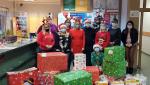 kilkanaście pracowników z urzędu z prezentami świątecznymi i czapeczkami mikołajkowymi