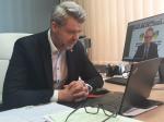 Dyrektor Izby Administracji Skarbowej w Zielonej Górze - Adam Andrzejewski siedzi przy biurku przed laptopem i uczestniczy w konwencie online