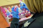 Funkcjonariuszka w rękawiczkach sprawdza zabawki w kształcie jajka