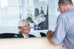 Okienko obsługi klienta na lotnisku. Kobieta w mundurze uśmiecha się do klienta.