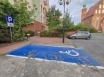 Wyznaczone na niebiesko miejsce parkingowe dla inwalidów koło Urzędu Skarbowego w Żarach