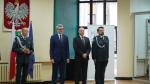 czterech mężczyzn stoi na tle godła Polski