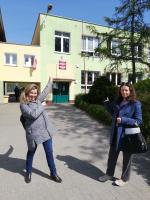 Dwie kobiety przed budynkiem szkoły. 