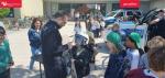 Funkcjonariusz z niemieckiej policji prezentuje dzieciom policyjną tarczę.