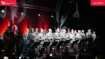 Scena na której stoją członkowie  Orkiestry Reprezentacyjnej Straży Granicznej. Wszyscy są w mundurach.