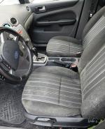 Wnętrze samochodu Ford Fokus utrzymane w czarno – szarej tonacji. Na kierownicy, tapicerce fotela kierowy i pasażera oraz na pasach bezpieczeństwa widoczne wykwity pleśni i grzybów.