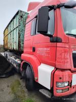 Prawa  strona samochodu ciężarowego marki MAN TGS 26.440  koloru czerwonego.  Napis w kolorze białym  na drzwiach  „Contanerdients 