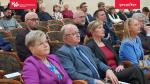 aula, w fotelach siedzi kilkadziesiąt zaproszonych osób