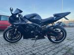 Motocykl Yamaha, model YZF-R1 koloru czarnego, ujęcie z lewej strony, felgi w kolorze czarnym z białym obramowaniem;