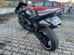 Motocykl Yamaha, model YZF-R1 koloru czarnego, ujęcie z lewej tylnej strony, felgi w kolorze czarnym z białym obramowaniem;