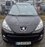 Przód czarnego Peugeot 207 ze srebrnymi relingami i logo marki na grilu, brak widocznych uszkodzeń nieznacznie przerysowana dolna część zderzaka