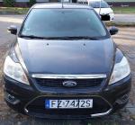 Przód granatowego samochodu Ford Fokus z widocznymi przetarciami w okolicy prawego światła przeciwmgłowego