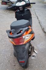 Tył motoroweru Junak w kolorze pomarańczowym z czarnymi wykończeniami, brak widocznych uszkodzeń