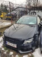 Przód czarnego AUDI A4, szyba czołowa bez uszkodzeń, widoczne uszkodzone lusterko