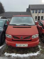 przód czerwonego VW Caravelle, szyba czołowa bez uszkodzeń, widoczne ślady eksploatacji, lakier bez połysku 