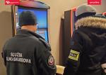 funkcjonariusz SCS i policji stoją przy dwóch nielegalnych automatach do gier hazardowych