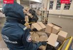 sortownia przesyłek, funkcjonariusz SCS trzyma karton z nielegalnym tytoniem