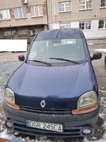 Przód granatowego Renault Kangoo, widoczne uszkodzenia lakiernicze i blacharskie, ślady rdzy, odpryski lakieru oraz ślady brudu po błocie