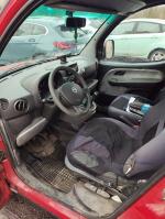 Wnętrze czerwonego Fiata Doblo, z widocznymi przetarciami tapicerki oraz przetarciami kierownicy 