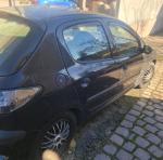 prawy bok granatowego Peugeot 206, z widocznymi wgnieceniami oraz zarysowaniami