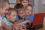 Grupa pięciu chłopców przed laptopem